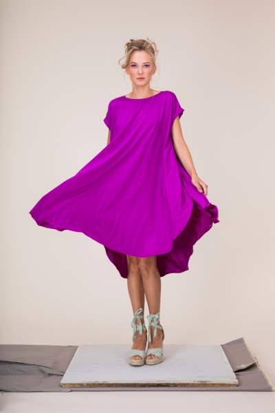 Woman in a loose purple dress against a light background.