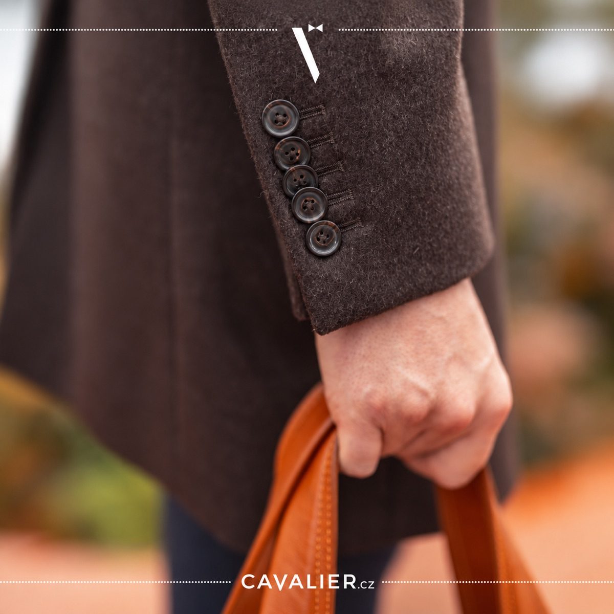 Close-up of five buttons on a brown coat sleeve and a brown leather bag.