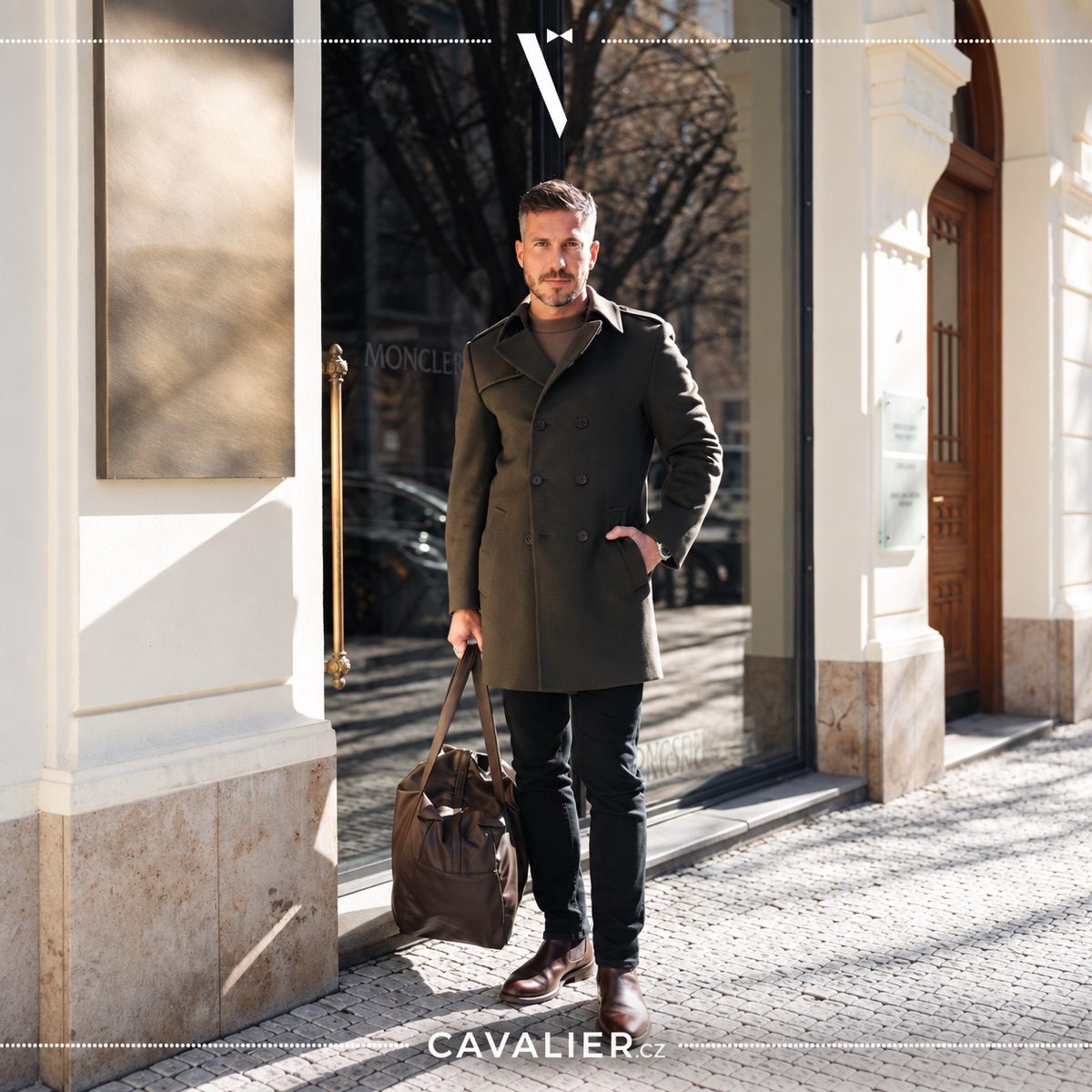 An olive made-to-measure men's coat in a smart casual outfit with a leather bag