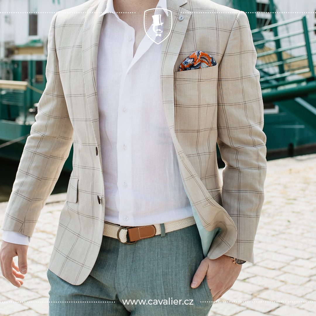 Detail of a light checked Cavalier linen jacket with a white shirt and green trousers