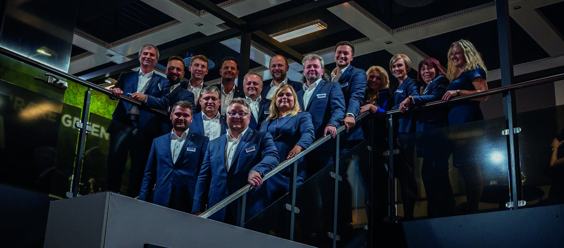 Men and women in coordinated blue outfits standing on a staircase