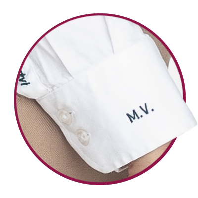 Folded white blouse cuff with initials.